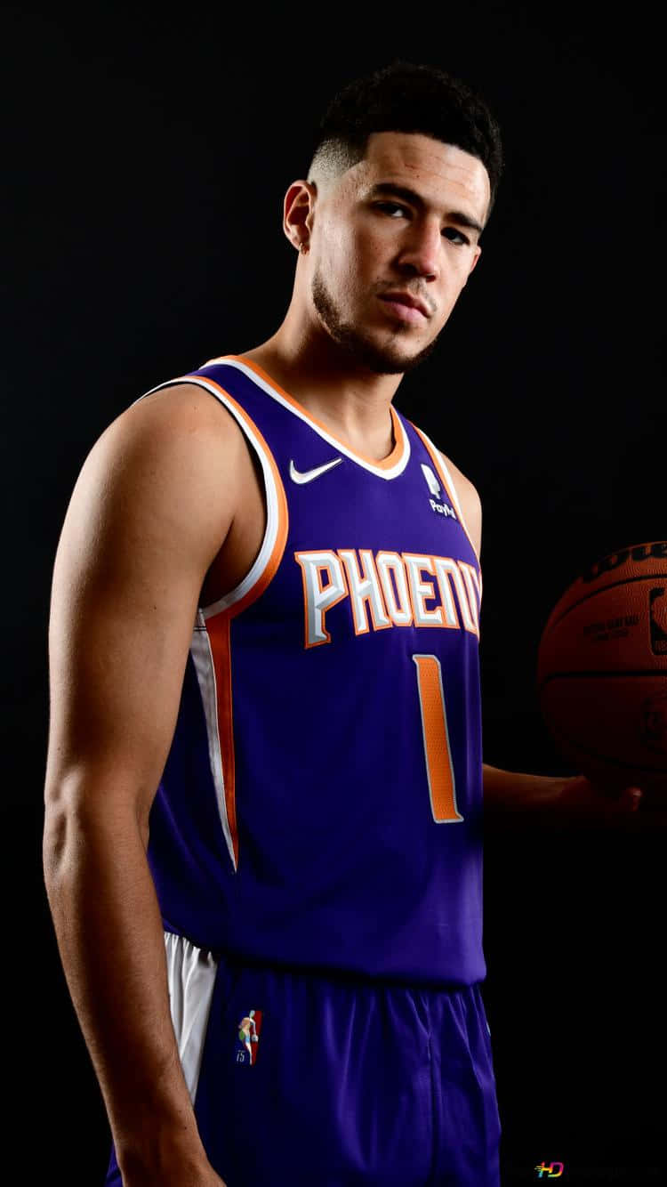 立即下載德文·布克iPhone壁紙，展現你對這位新興NBA球星的支持。 壁紙 — 一位身穿紫色鳳凰城太陽隊球衣的籃球運動員，在黑色背景前專注地持球。