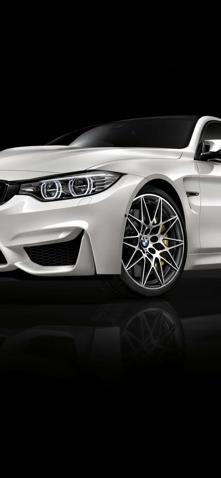 白色BMW跑車，帶金色制動卡鉗，置於黑色反光表面。