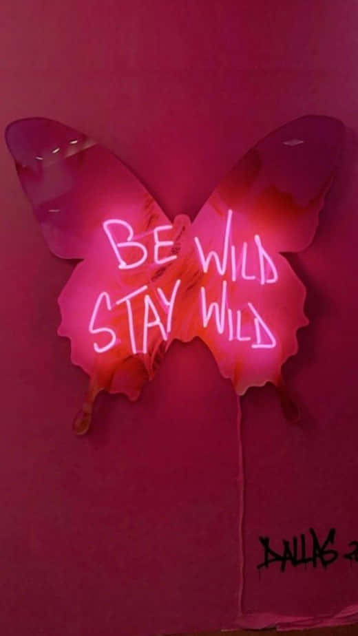粉紅色霓虹燈蝴蝶標誌，在粉紅色牆壁上帶有塗鴉，寫着「Be Wild Stay Wild」。