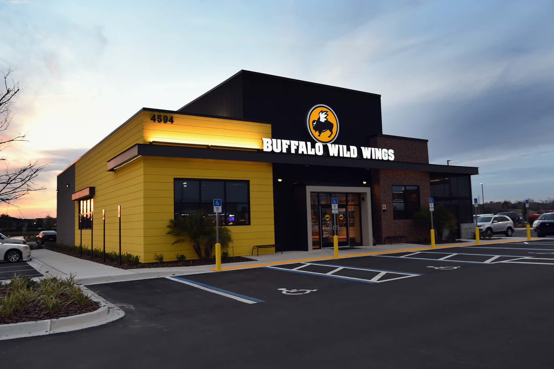 Buffalo Wild Wings 餐廳外部在黃昏時分，設有停車場和陰天天空。