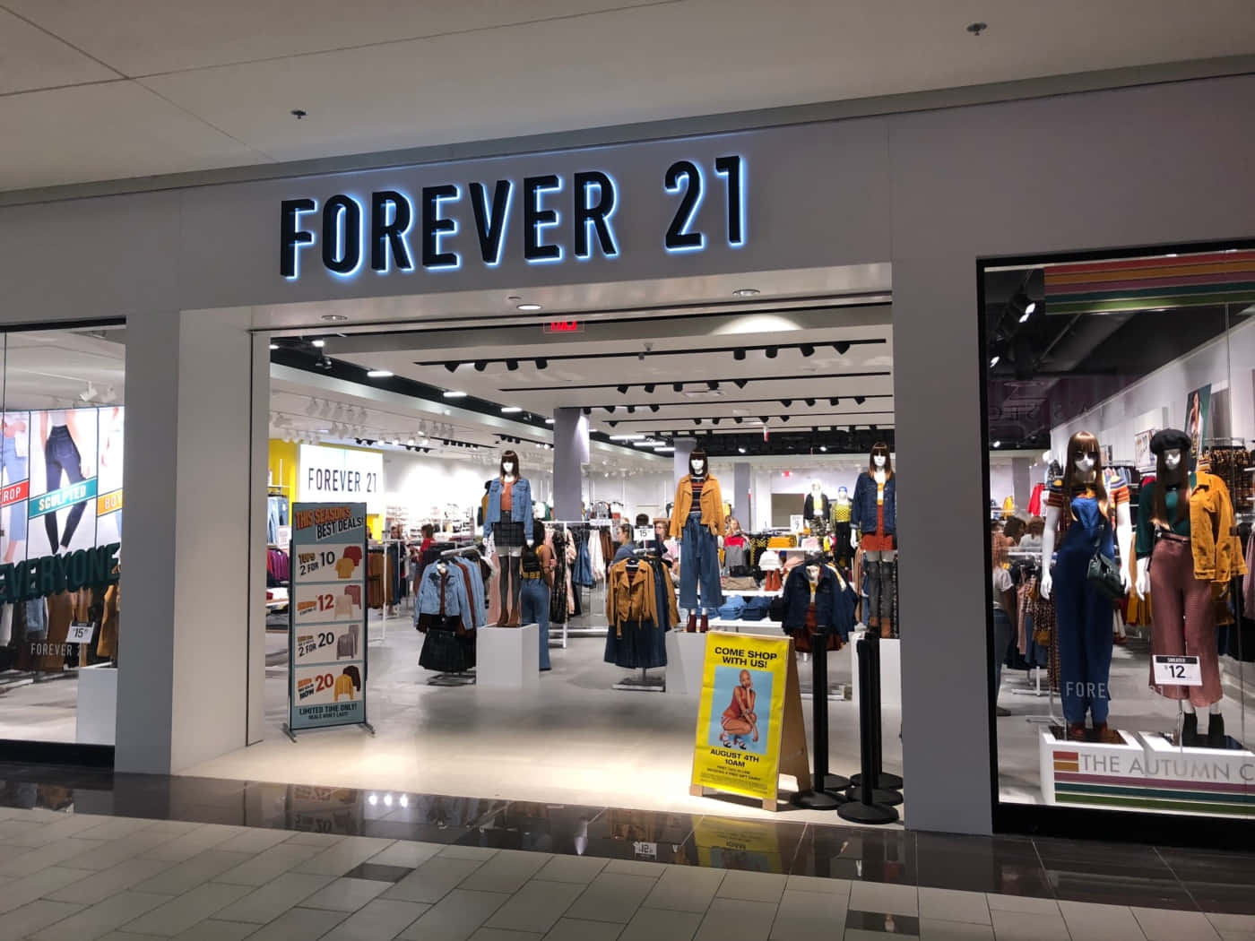 立即探索 Forever 21 最新時尚 壁紙 — 購物中心內一間Forever 21店舖入口燈光明亮，展示身穿秋季時裝的人體模型及減價標誌。