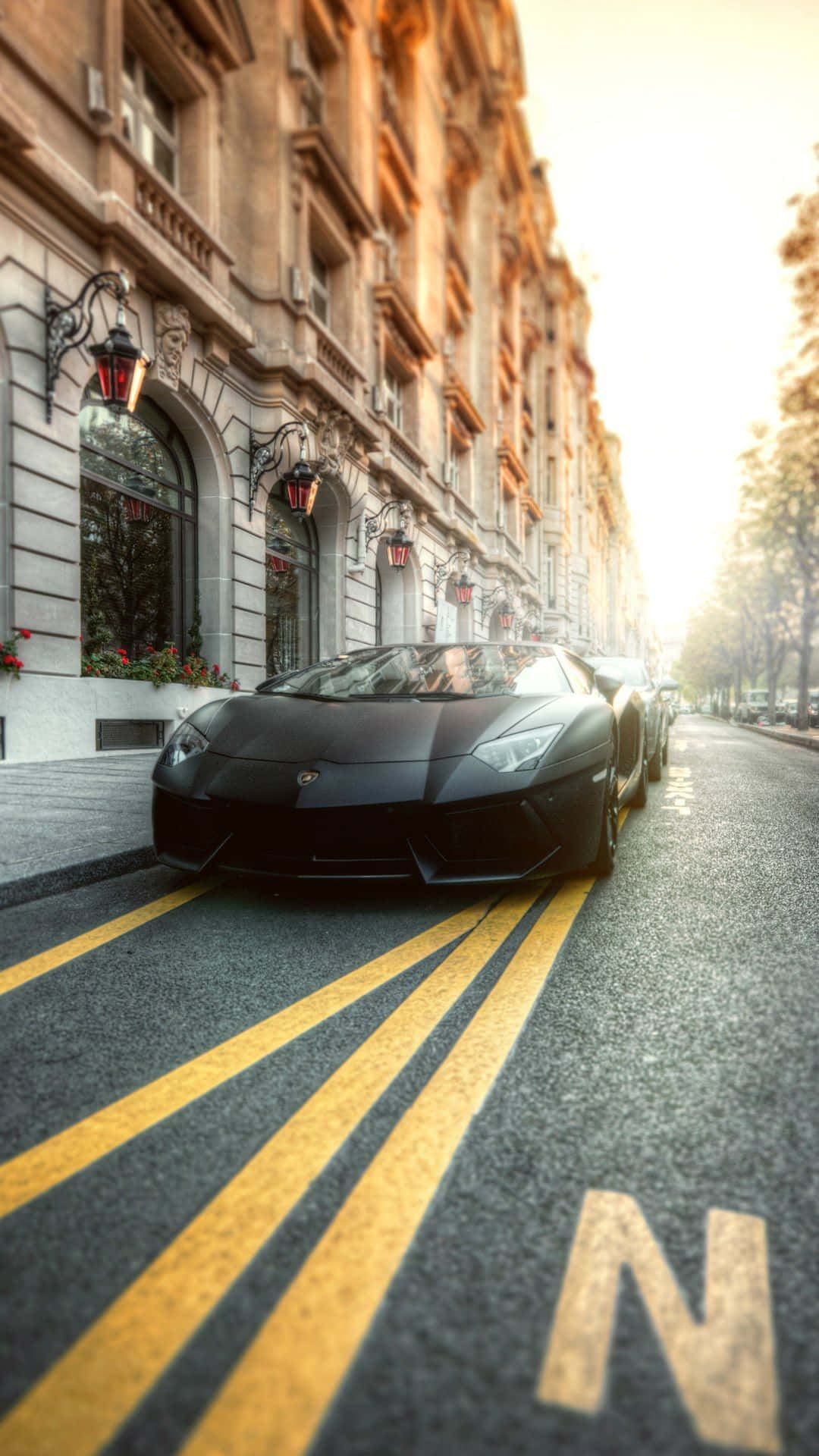 日落時分停泊在城巿街道上的黑色跑車。