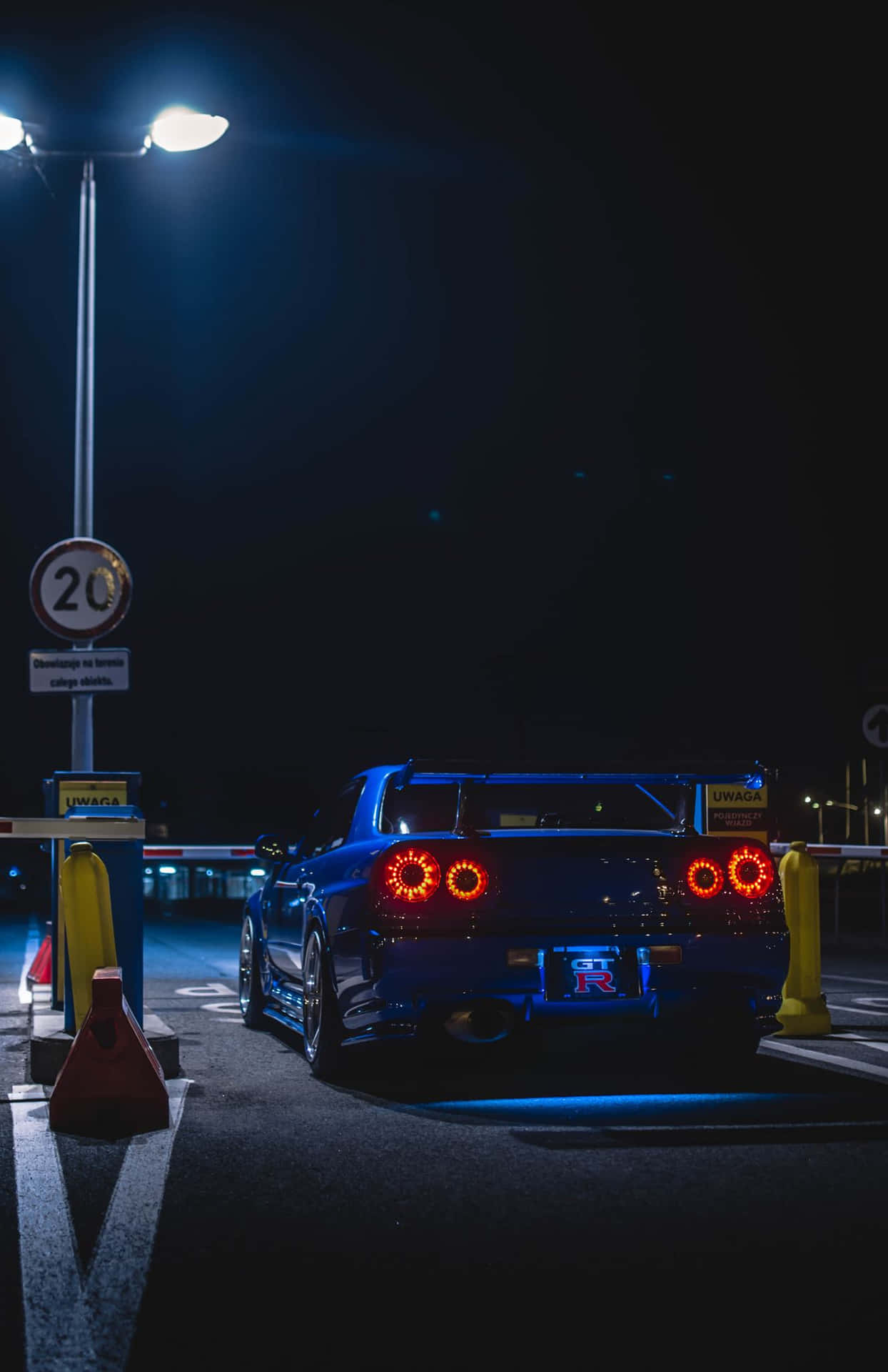 夜間收費站的藍色跑車，帶有發光的紅色尾燈。