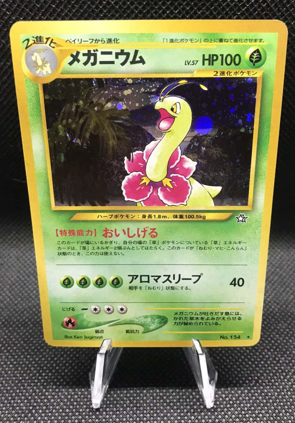 一張Pokémon交易卡，展示帶有粉紅色花瓣的Mega Bayleef，展示在透明支架上。