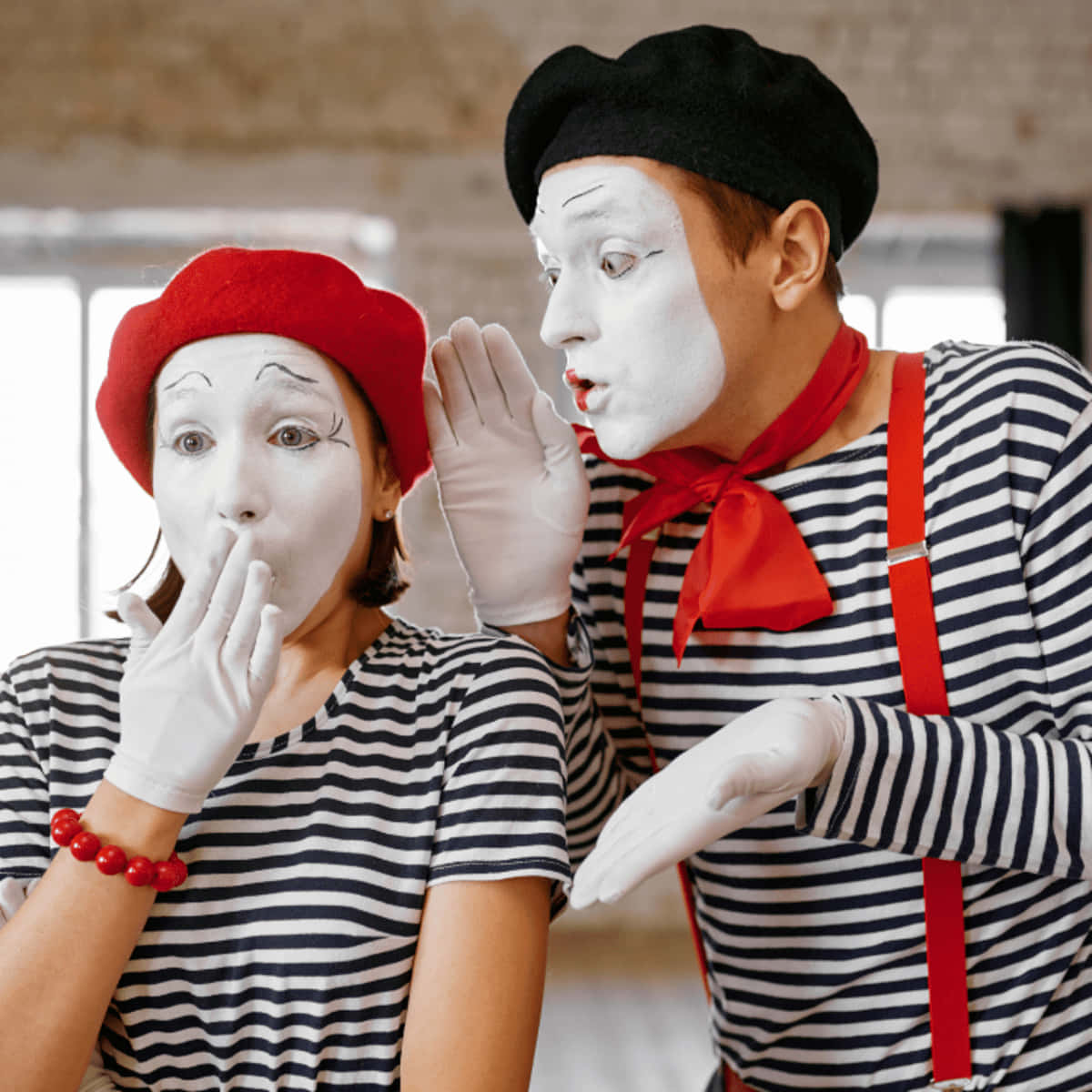 笑到肚子痛！ 壁紙 — 兩位身穿經典條紋服裝、臉塗白色的默劇演員在陽光充足的房間裡分享秘密低語。