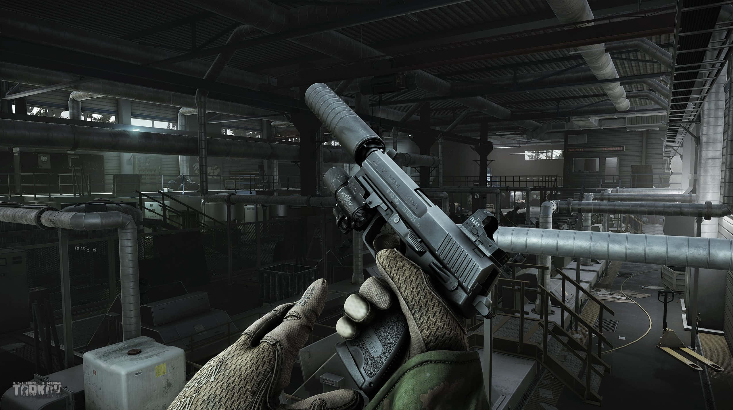 Fps Games 桌布 壁紙 — 第一人稱視角，一隻戴著手套的手在光線昏暗的工業設施中握著一把帶有消音器的手槍，周圍有暴露的管道和金屬走道。