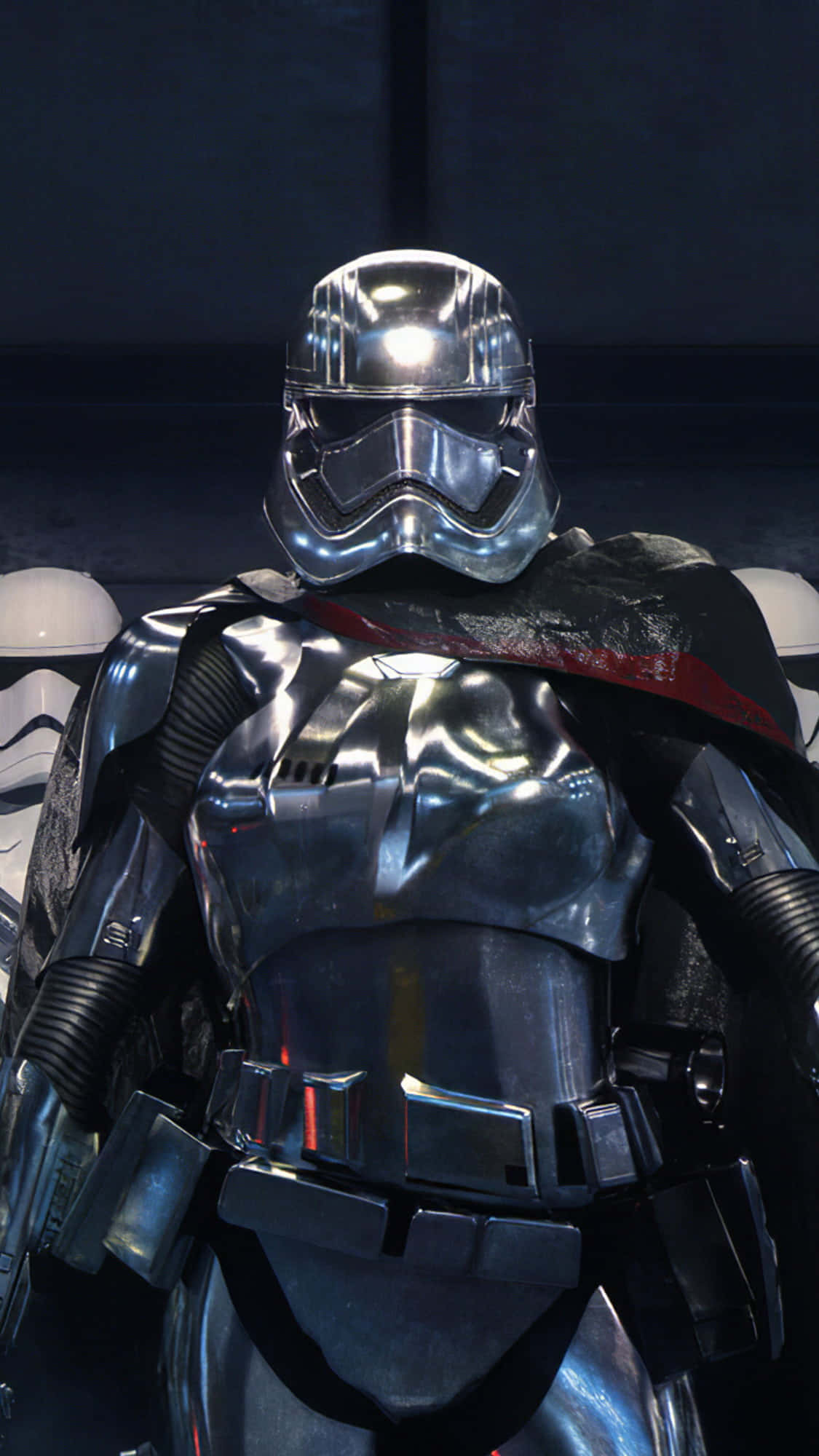 Captain Phasma 桌布 壁紙 — 第一秩序軍官身穿反光鉻合金盔甲和紅色襯裡斗篷，在昏暗燈光下的特寫。