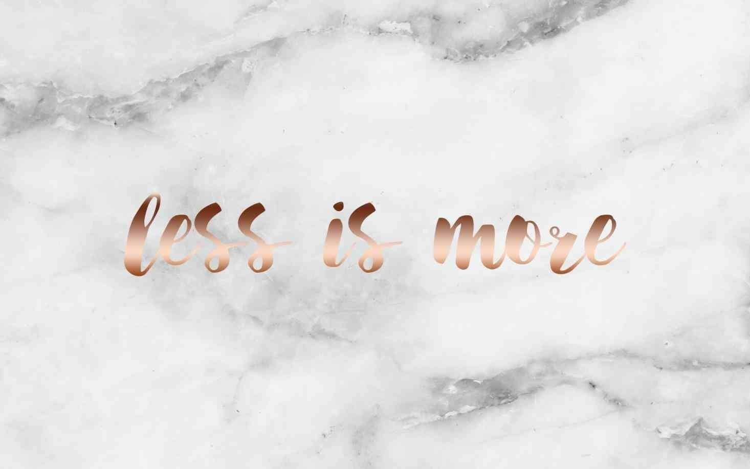 白色大理石背景上的玫瑰金色 less is more 文字