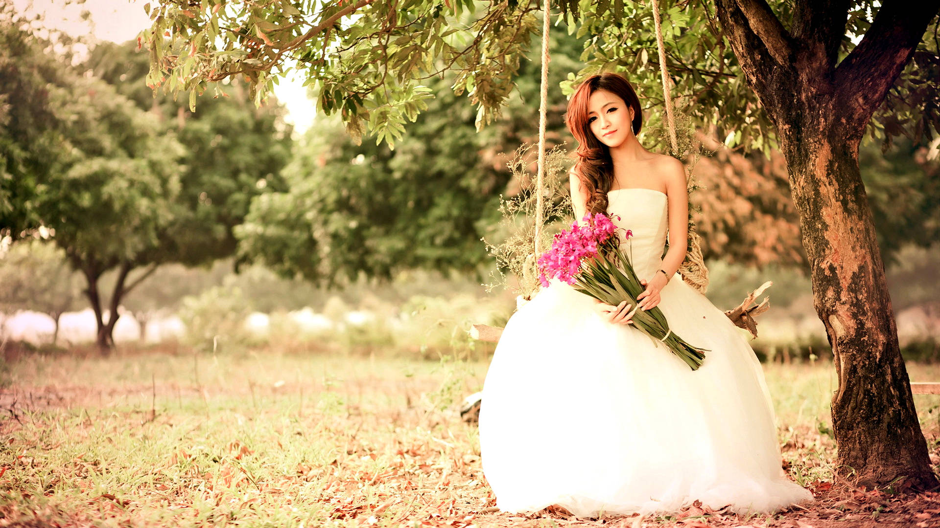 簡約中的優雅——現代新娘 壁紙 — 一位身穿白色婚紗的新娘，在寧靜的公園裡，樹影斑駁的陽光下，優雅地坐在樹鞦韆上，手持粉紅色的花朵。