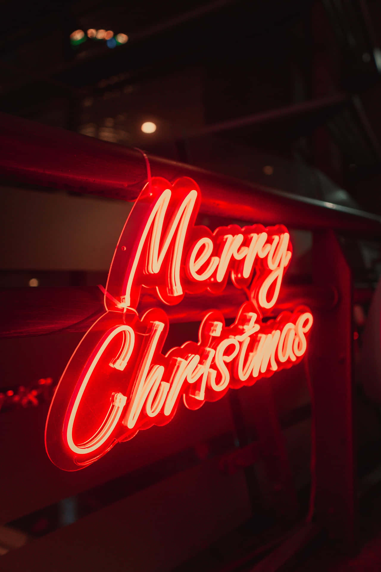 在黑暗的城市環境中發光的紅色霓虹 Merry Christmas 標誌。