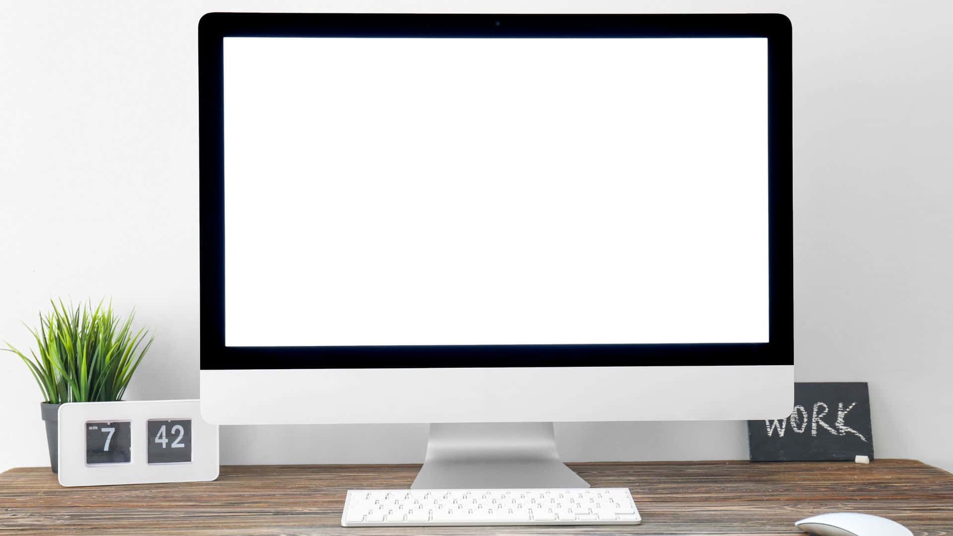 Computer Screen 桌布 壁紙 — 簡約家居辦公室設置，白色iMac放在木桌上，旁邊有綠色植物、數碼時鐘和寫着work的黑板標誌。