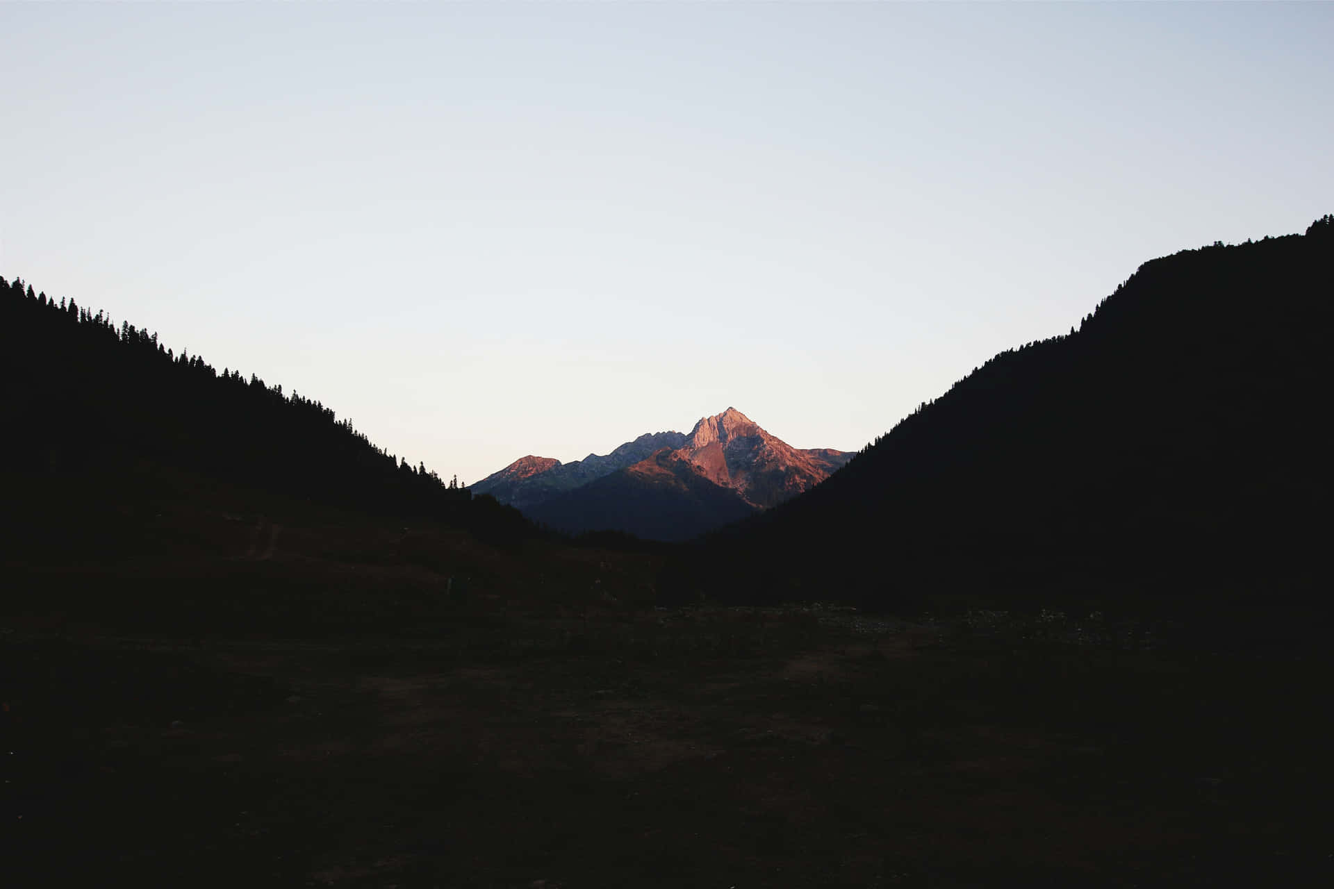 黃昏時分的剪影山脈，沐浴在日落光芒中的閃耀山峰。