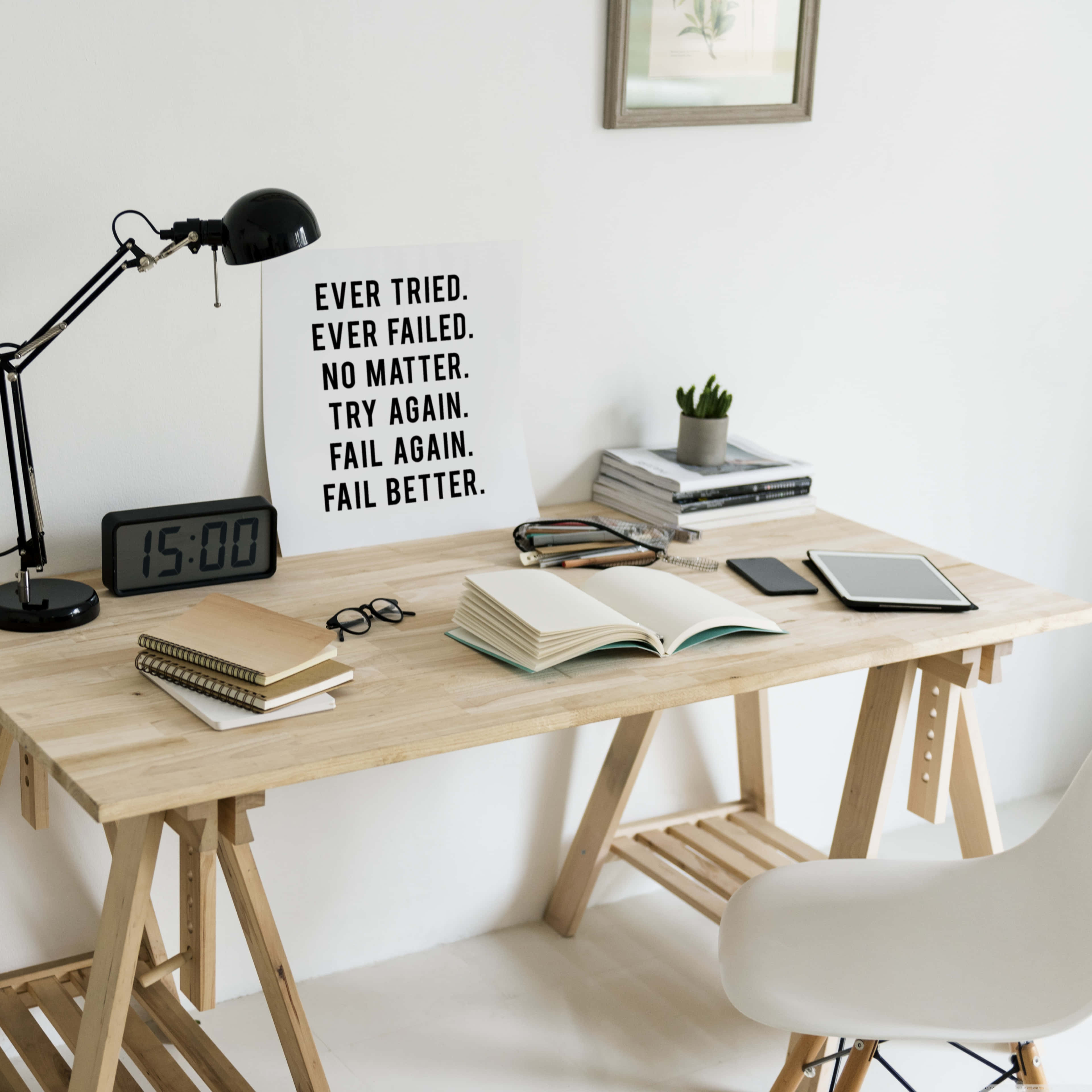 Minimalist Quote 桌布 壁紙 — 簡約木桌，配有勵志海報、打開的書本和黑色檯燈，位於明亮的白色房間內。