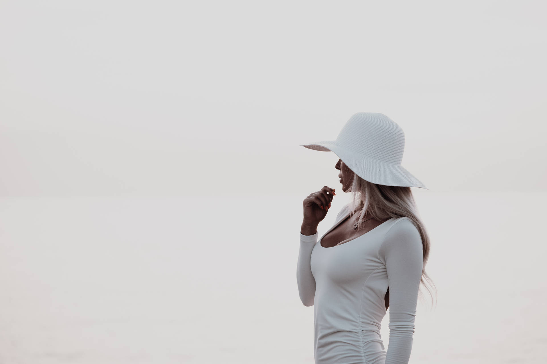 戴白色帽子和上衣的女性站在朦朧的戶外環境中