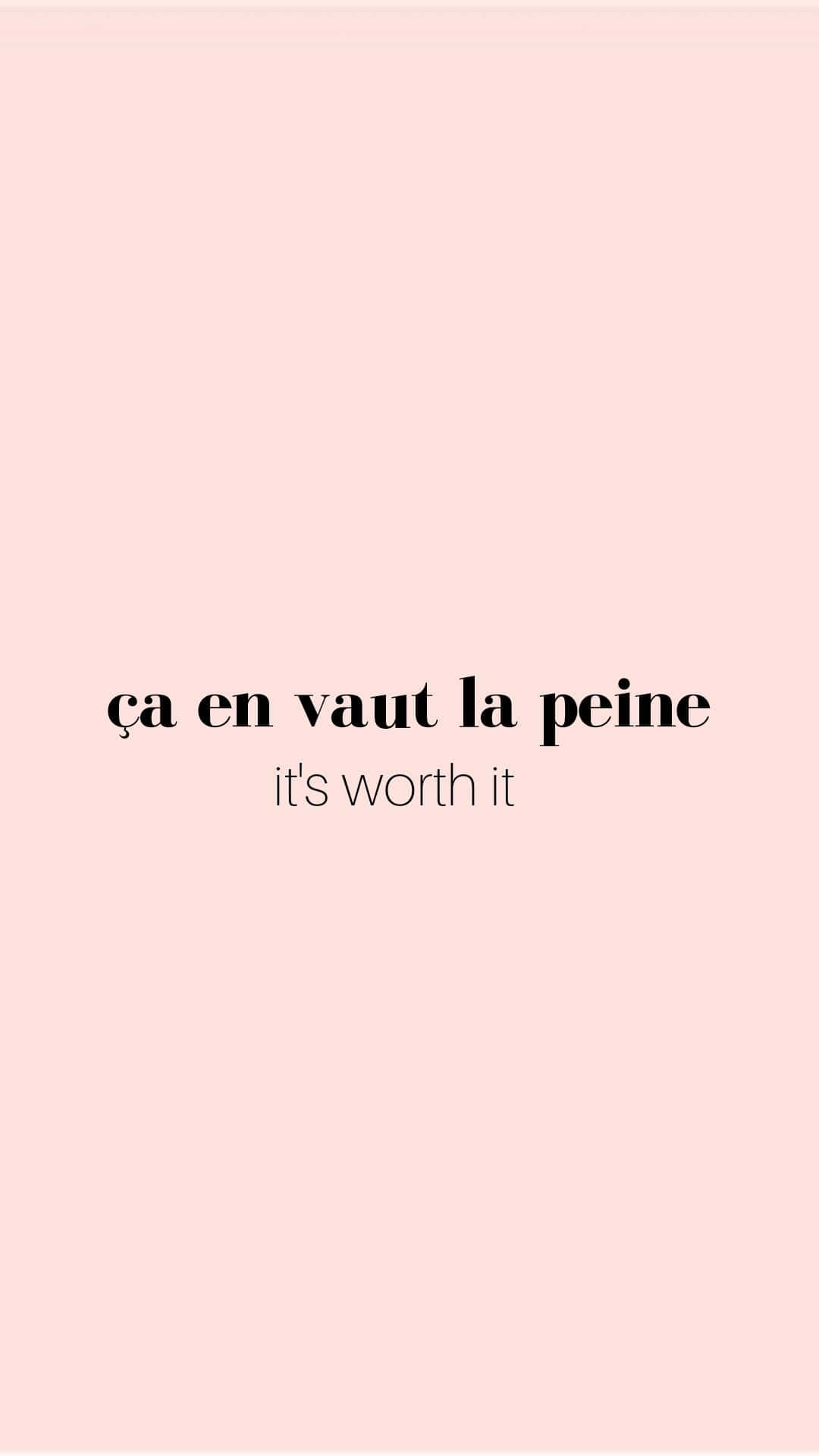 french 桌布 壁紙 — 簡約粉紅色背景，中央黑色文字寫著 ça en vaut la peine it's worth it。