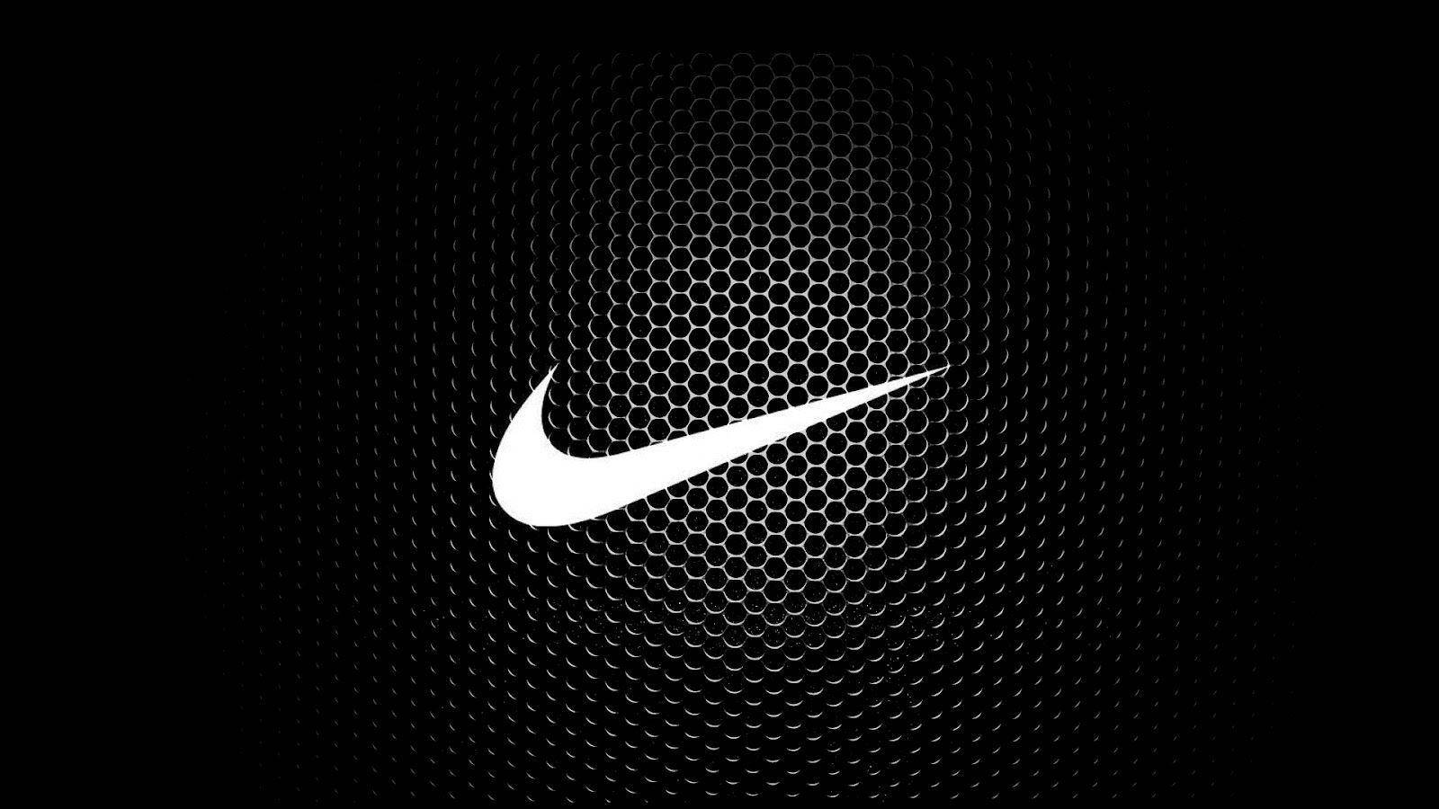 簡約耐克標誌 壁紙 — 一個大膽的白色Nike swoosh標誌，居中在黑色六角形網格背景上，帶有微妙的徑向漸變。