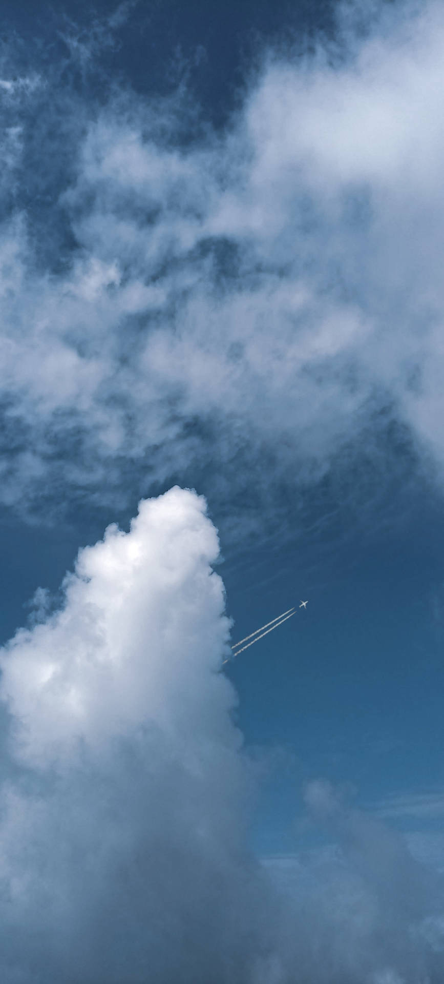 飛機在雲層上方高空飛行，留下一道凝結尾跡