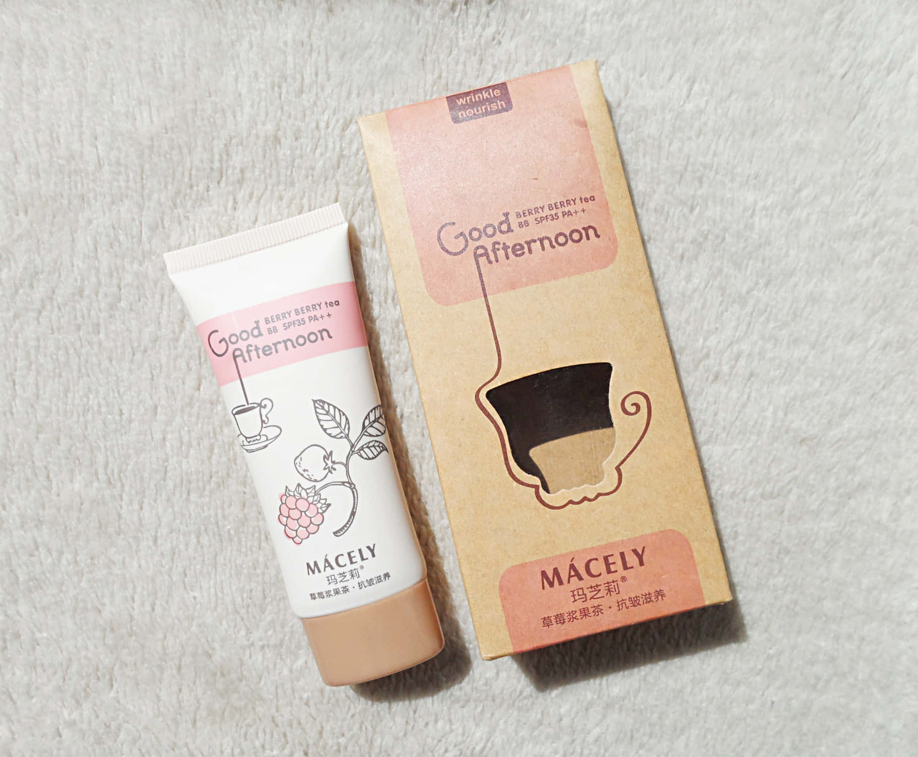 Mácely Good Afternoon berry berry茶防曬霜管和盒子在紋理白色表面上。