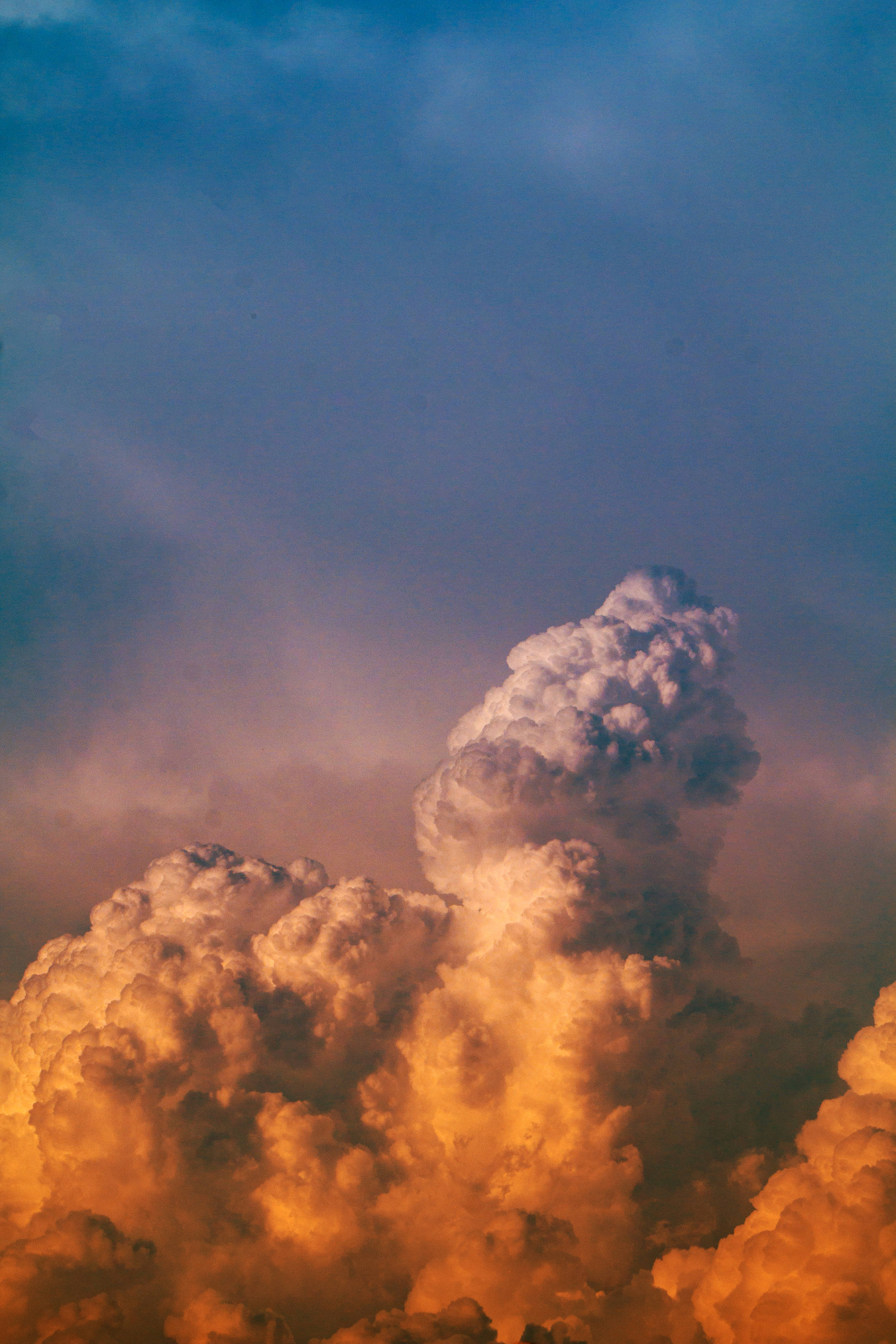 簡約高清多雲天空 壁紙 — 戲劇性的積雨雲在暮色天空中閃耀著琥珀色和紫色。