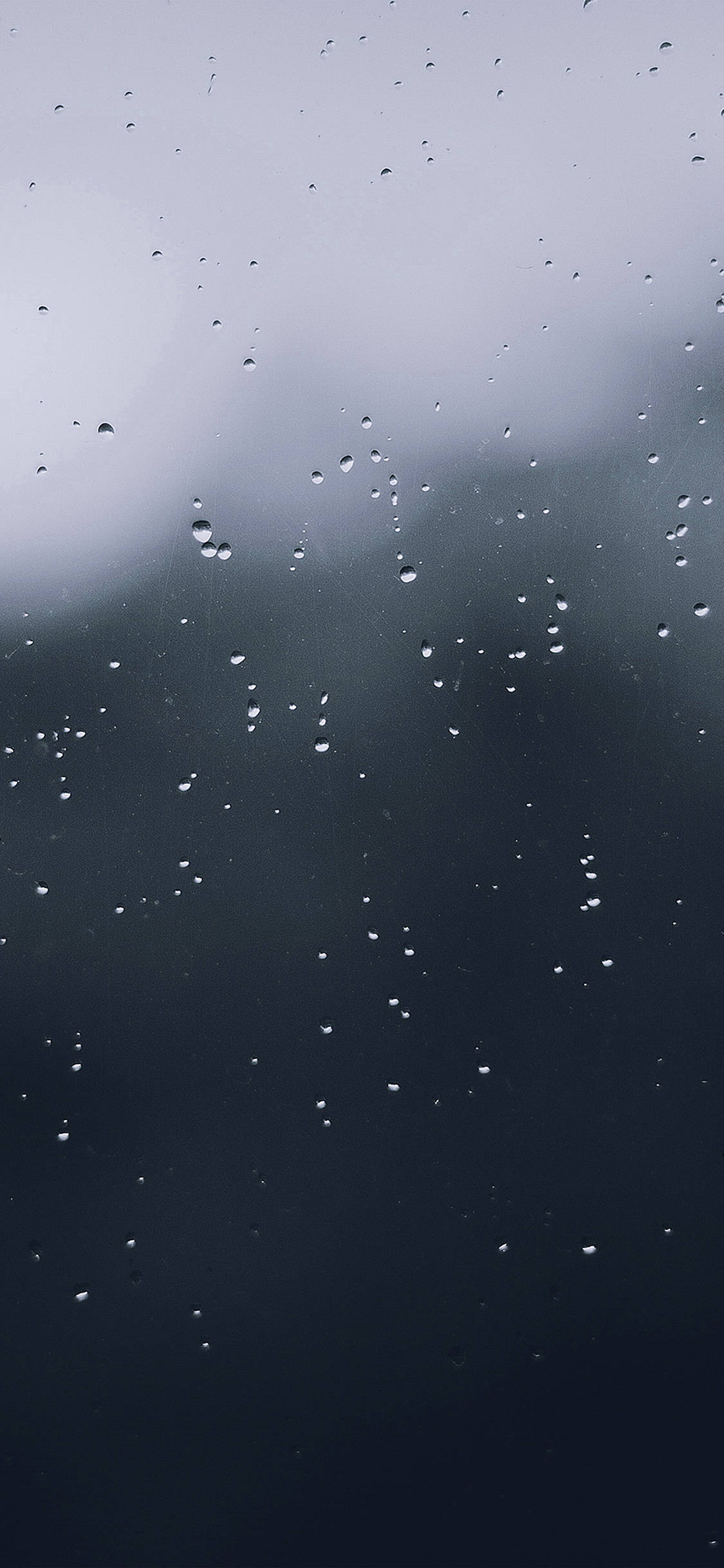 簡約高清水滴 壁紙 — 雨滴依附在玻璃窗上，陰沉天空由灰色漸變為深藍色。