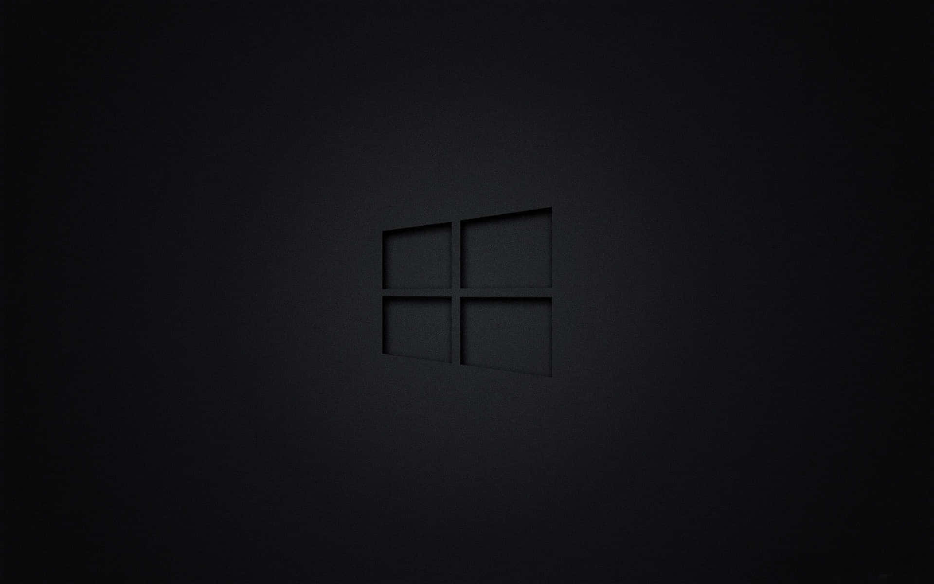 Windows標誌壓印在啞光深色表面上，柔和燈光。