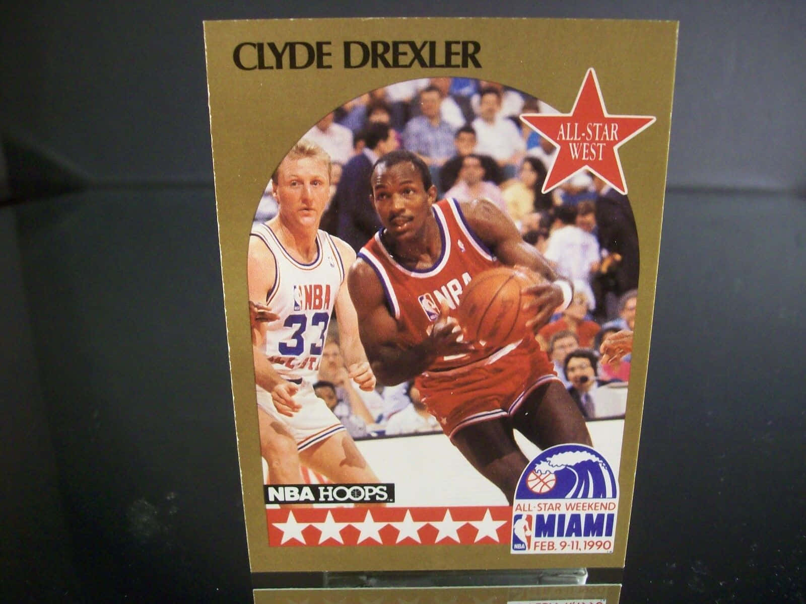 籃球傳奇克萊德·德雷克斯勒賽場動態 壁紙 — 1990年NBA全明星週末復古交易卡，展示身穿紅色球衣的Clyde Drexler運球越過防守球員。