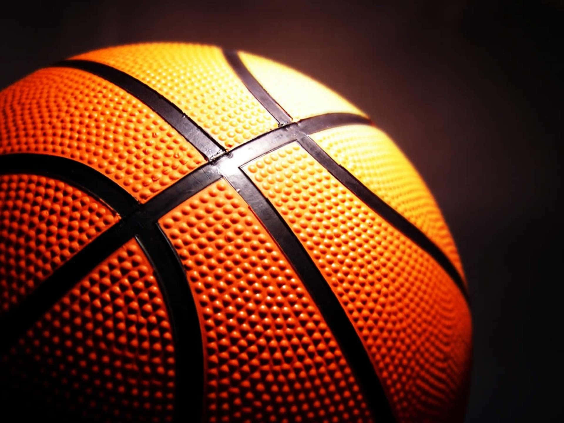 ball 桌布 壁紙 — 籃球在黑暗背景下發出溫暖光芒的特寫。