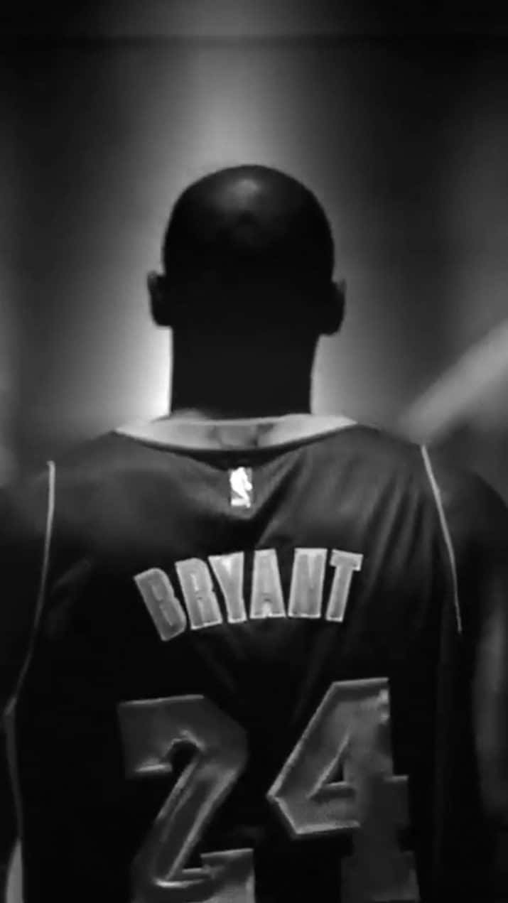 Kobe 桌布 壁紙 — 籃球運動員身穿 Bryant 24 球衣的背影，在發光的隧道中形成剪影。