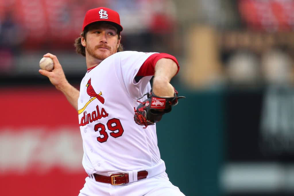 身穿 Cardinals 球衣的棒球投手在比賽中投球。