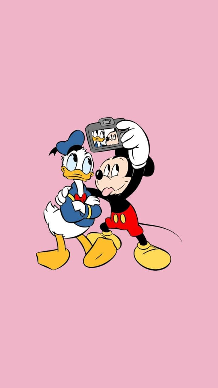 Cartoon Characters 桌布 壁紙 — 米奇老鼠和高飛狗一起擺姿勢，在純粉紅色背景前用相機自拍。