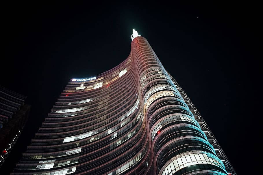 一座現代弧形摩天大樓在城市的夜晚被點亮。