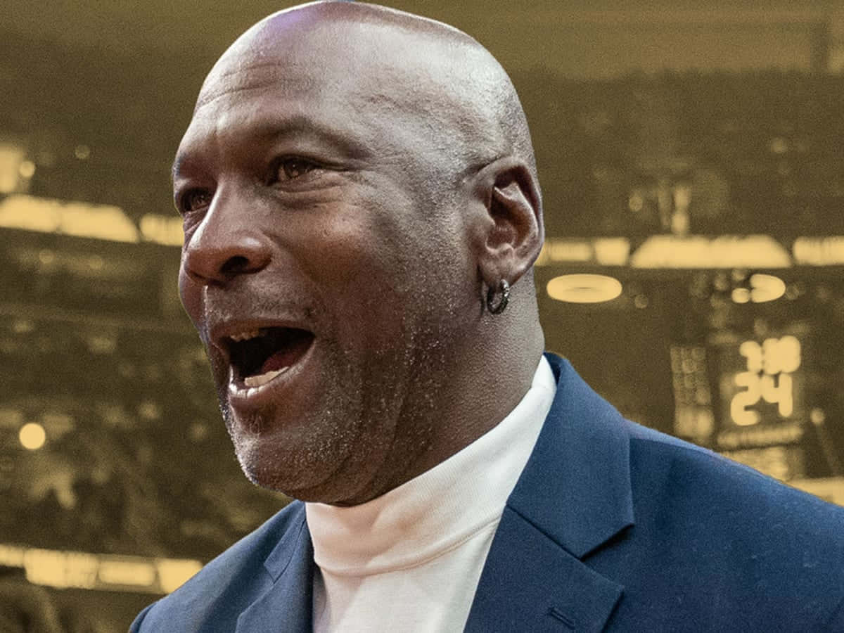 Jordan 桌布 壁紙 — 米高佐敦身穿藍色西裝，在模糊的籃球場背景下燦爛地微笑。