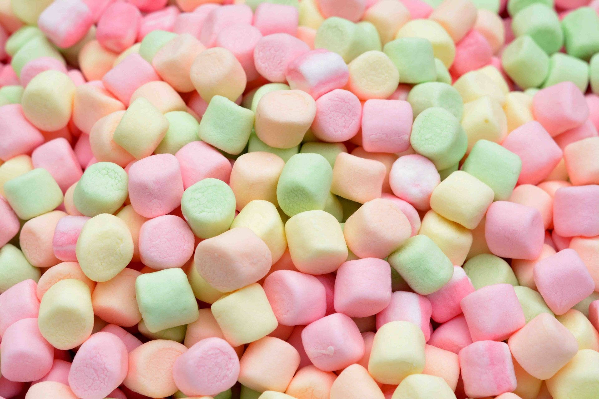 Marshmallow 桌布 壁紙 — 粉紅、粉綠和粉黃色棉花糖堆疊在一起的近距離特寫，呈現柔軟蓬鬆的質感。