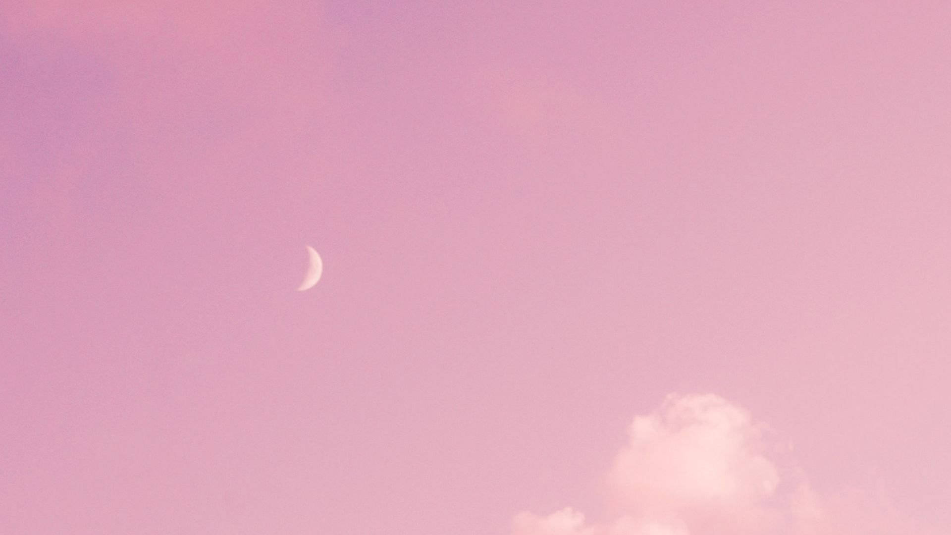 粉紅天空中的月牙與柔雲暮色