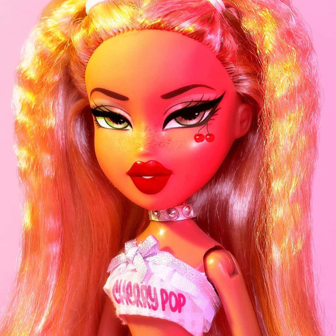 粉紅時尚Bratz玩偶Chloe 壁紙 — 一個特寫鏡頭，一個擁有火橙色頭髮和櫻桃臉頰裝飾的娃娃，背景為粉紅色。
