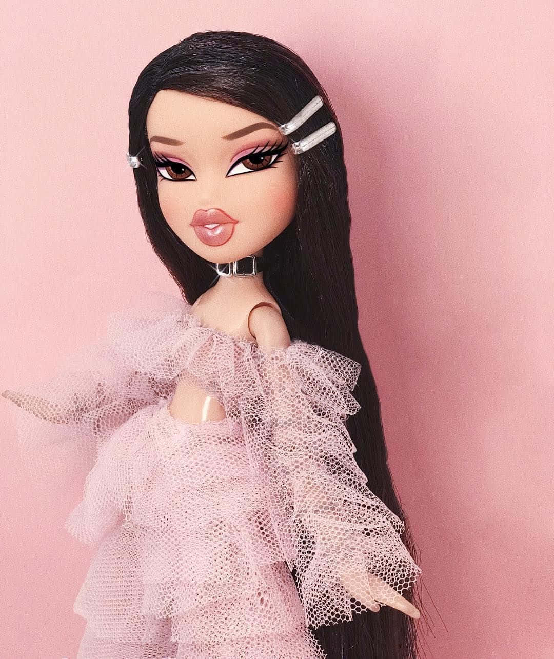 穿著粉紅色薄紗裙、長長黑髮和銀色髮夾的 Bratz 公仔。 — Bratz風格 壁紙