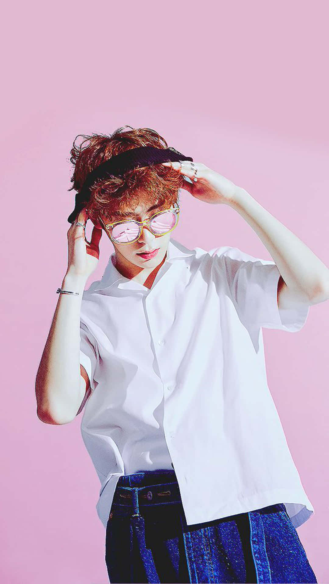 捲髮和粉紅色眼鏡的人，在粉紅色背景上調整頭帶。