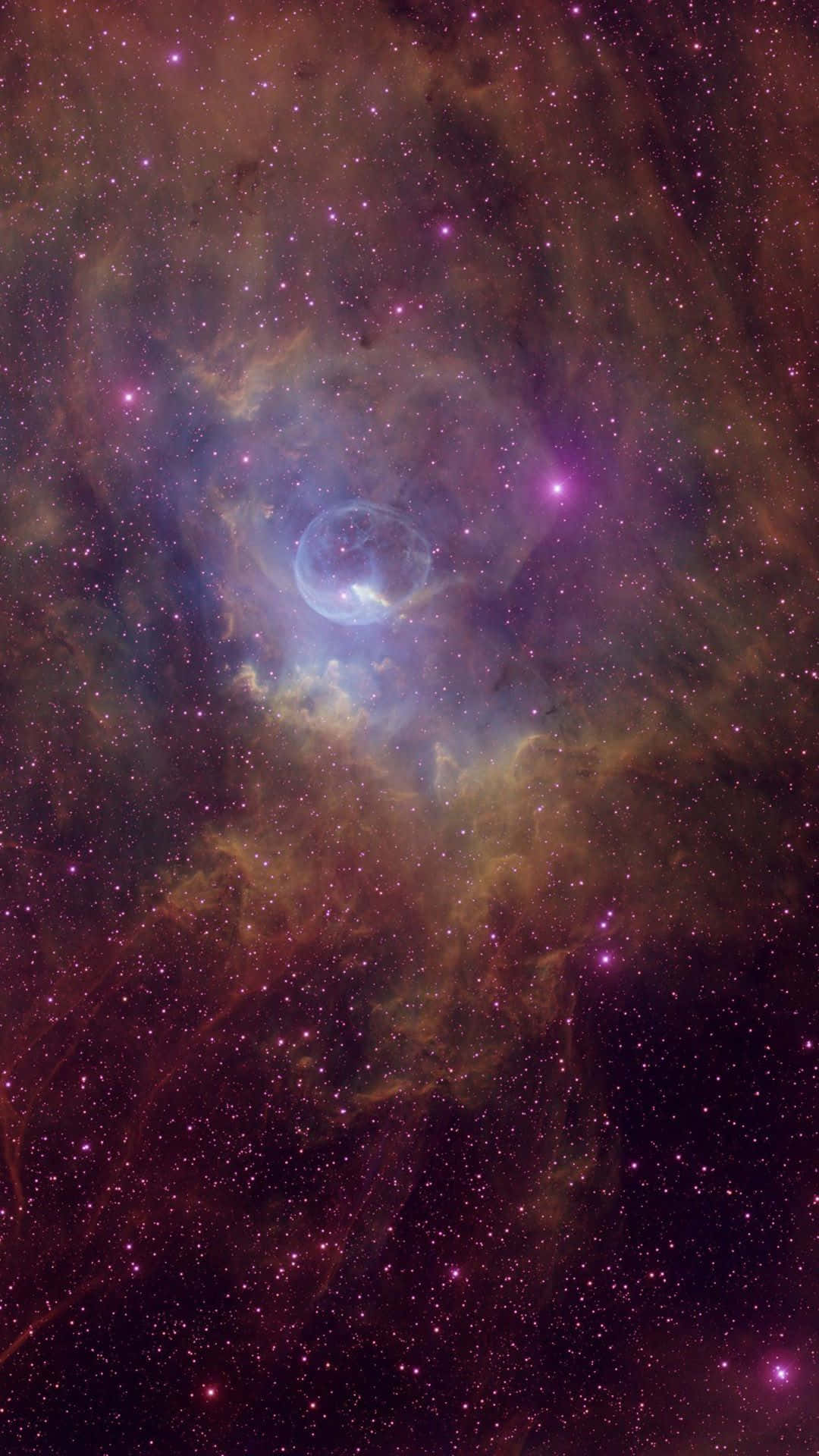 粉紅與橙色星星星空背景 壁紙 — 一個宇宙星雲在星空中散發著充滿活力的紫色和橙色光芒，中心有一個發光的藍色氣泡。