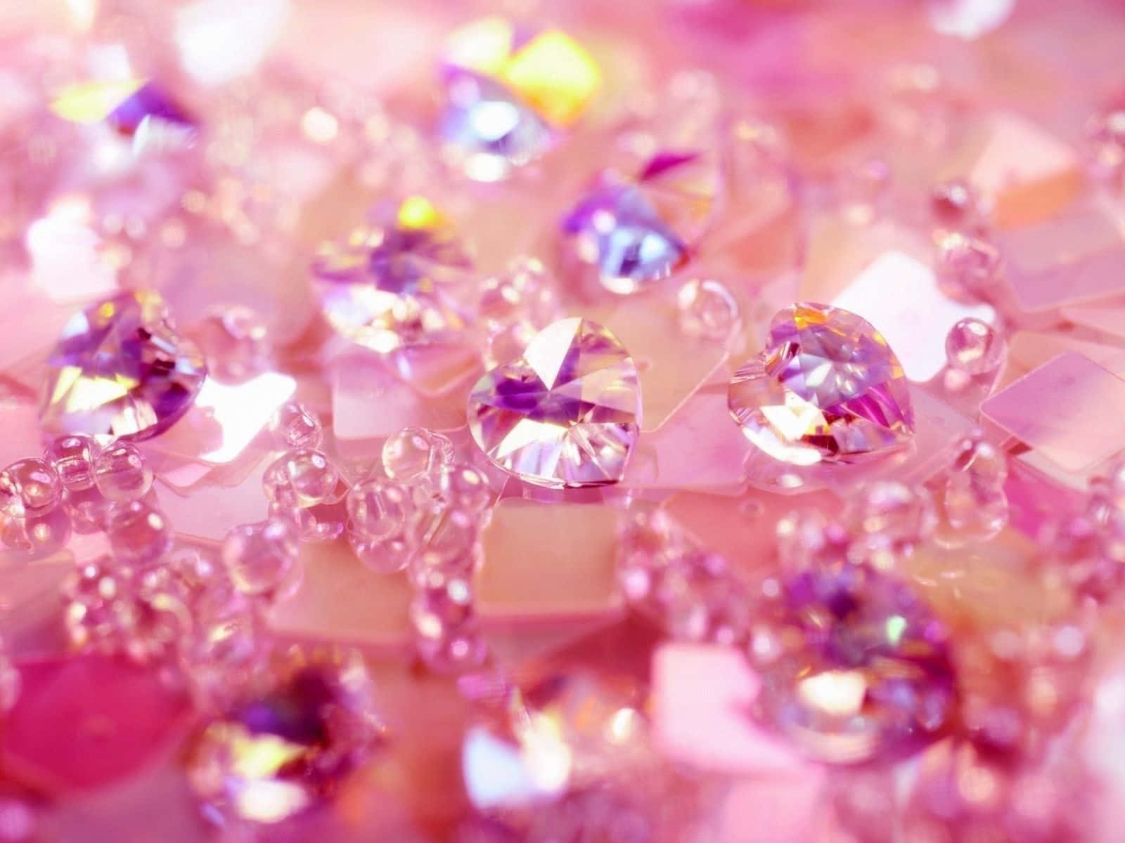 Pink Crystal Quartz 桌布 壁紙 — 粉紅色和紫色心形水晶和珠子的特寫，在柔和的光線下閃閃發光。