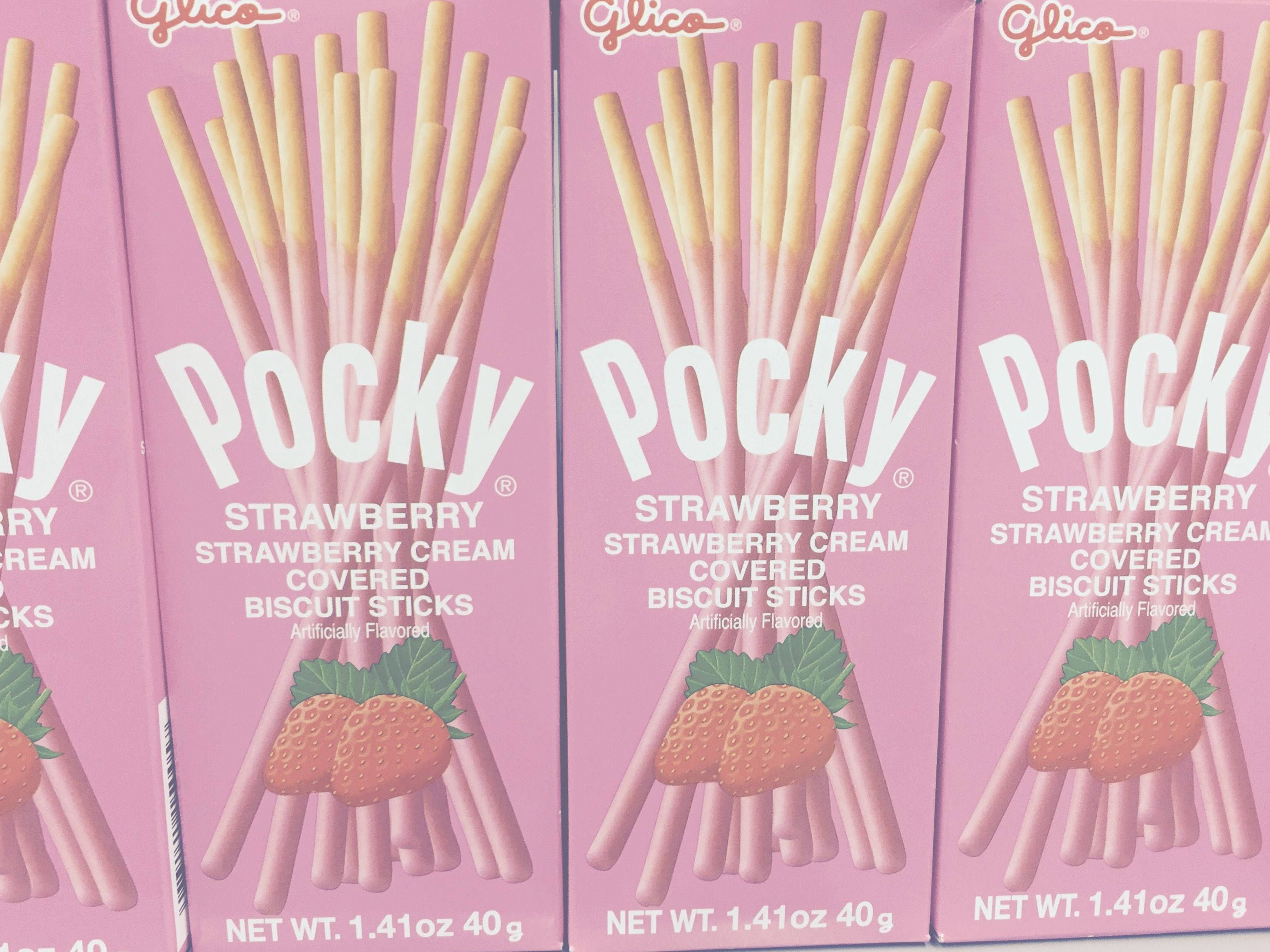 Snacks 桌布 壁紙 — 粉紅色嘅Glico Pocky士多啤梨忌廉餅乾棒盒以重複圖案排列。