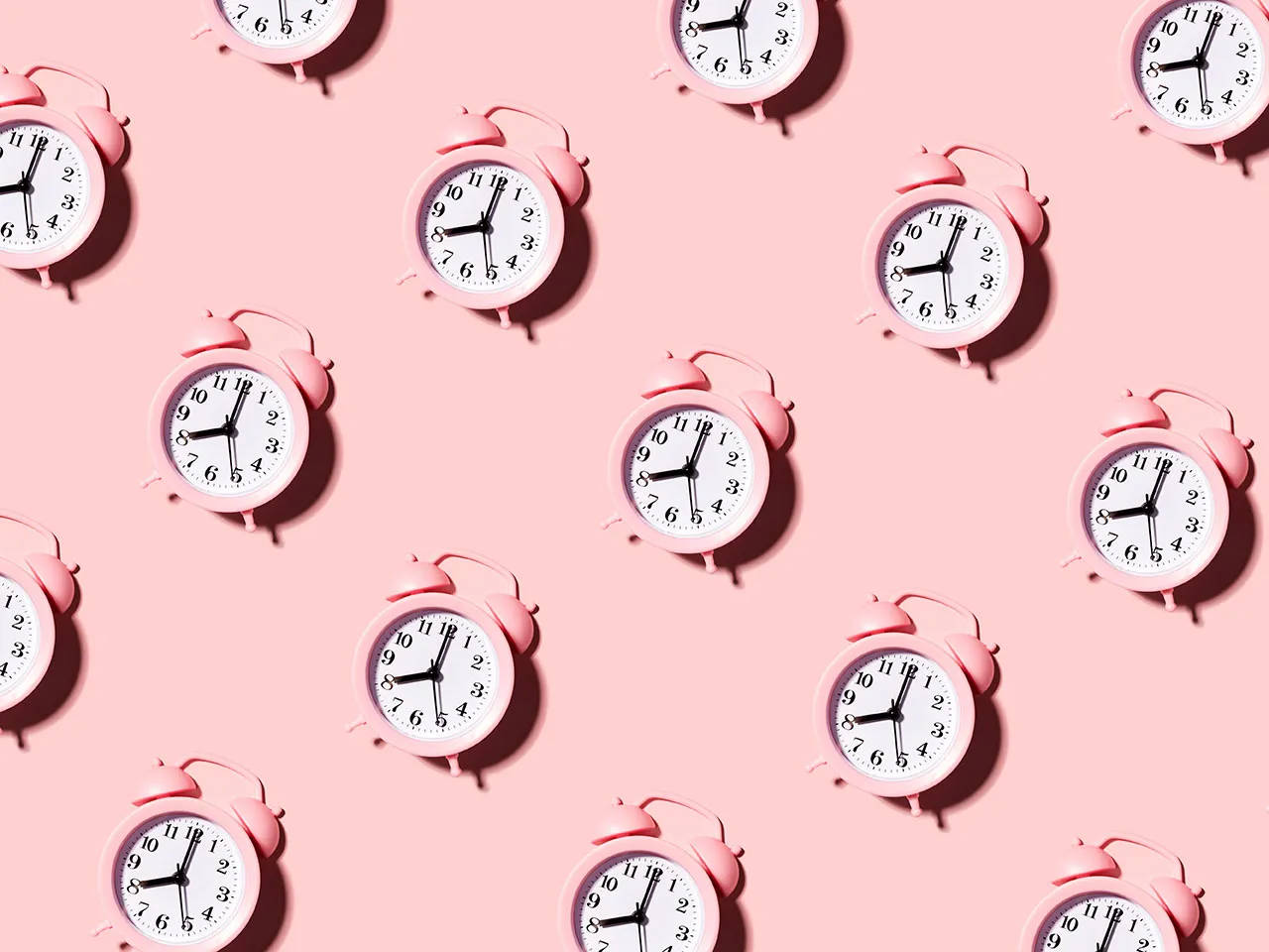 Clocks 桌布 壁紙 — 粉紅色復古鬧鐘散落在柔和的粉紅色背景上，形成重複圖案。