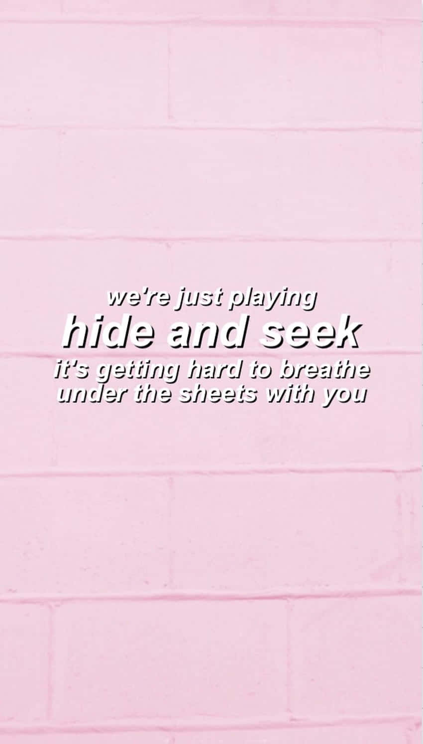 Melanie Martinez 桌布 壁紙 — 粉紅色磚牆背景，帶有白色浪漫文字疊加，關於捉迷藏和在被單下呼吸。