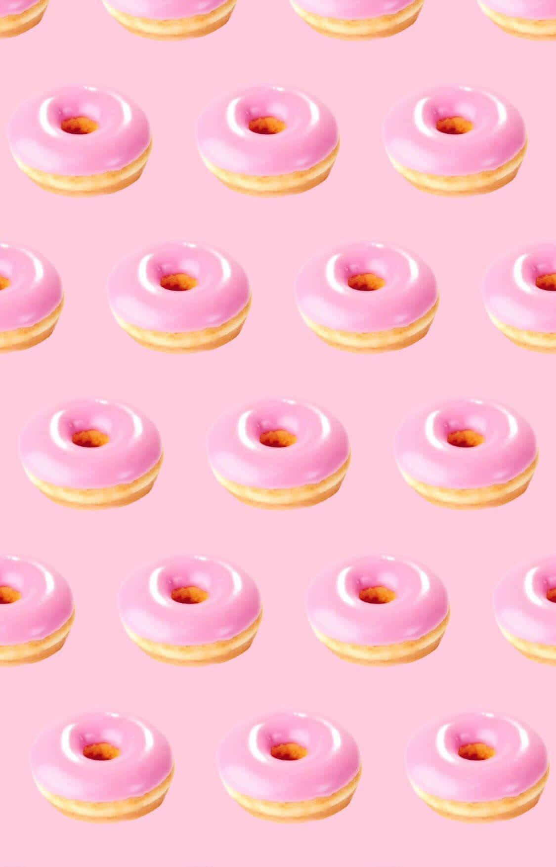 Cute Donut 桌布 壁紙 — 粉紅色糖霜冬甩整齊排列在柔和的粉紅色背景上。