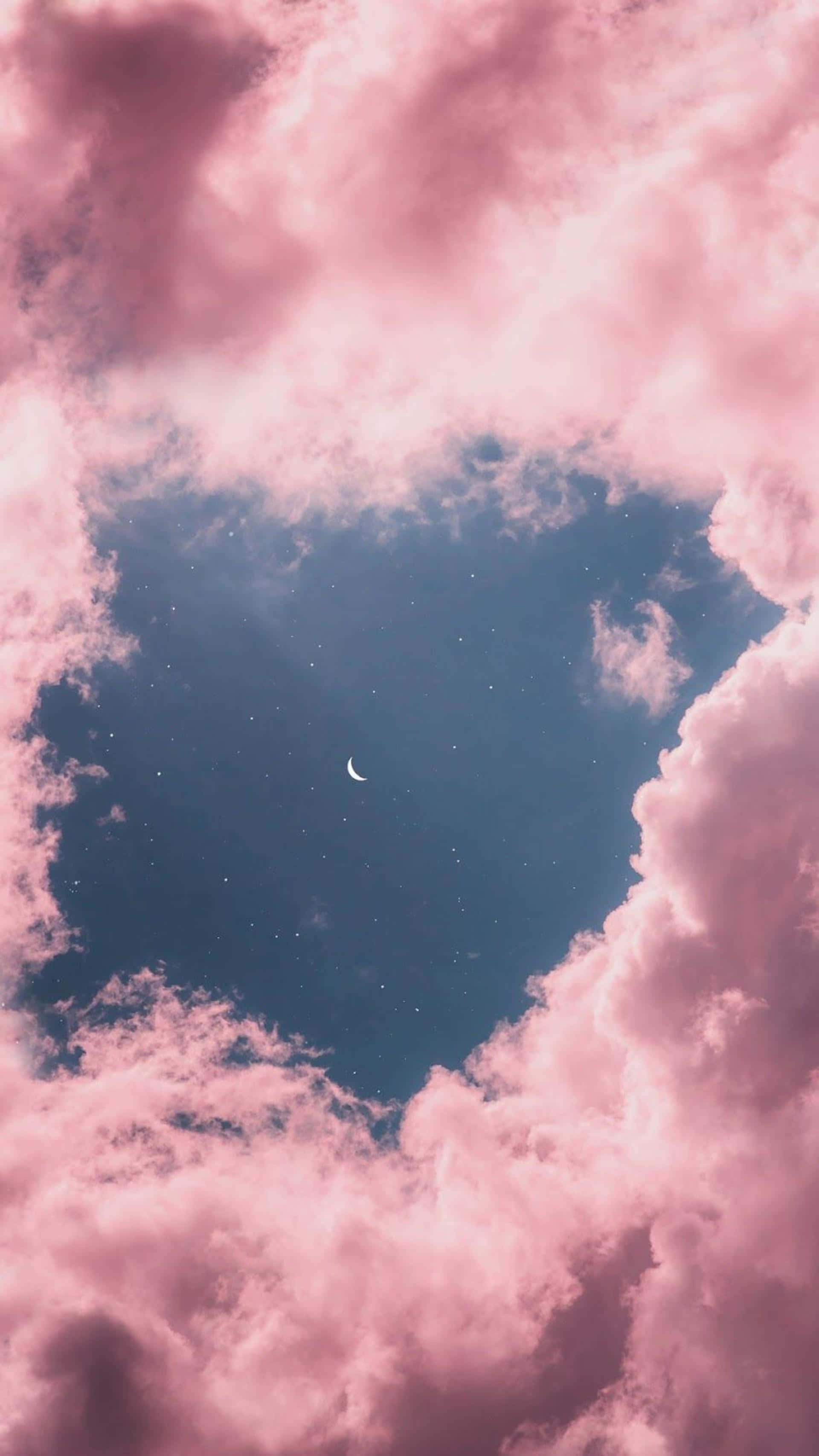粉紅雲朵天空圖片 壁紙 — 粉紅色的雲朵形成心形，框住夢幻夜空中的新月和星星。