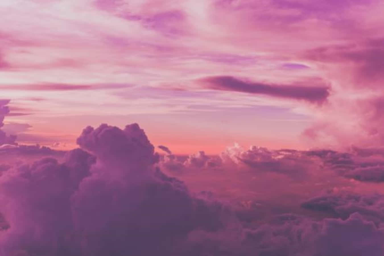 粉紅雲朵懸空畫 壁紙 — 夢幻的天空，充滿柔和的粉紅色和紫色雲彩，在超現實的日落中發光。