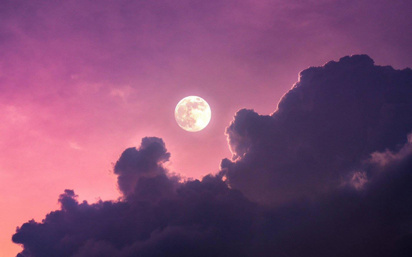 滿月透過紫色雲層在粉紅色夜空中閃耀