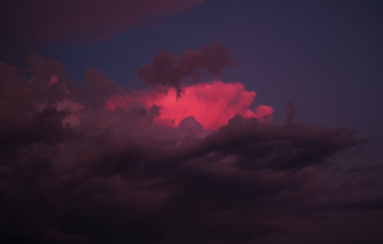 深紫色暮色天空中閃耀的粉紅色雲朵