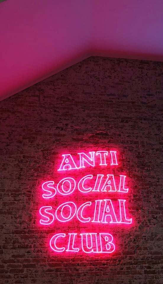 磚牆上寫著「Anti Social Social Club」的粉紅色霓虹燈牌。