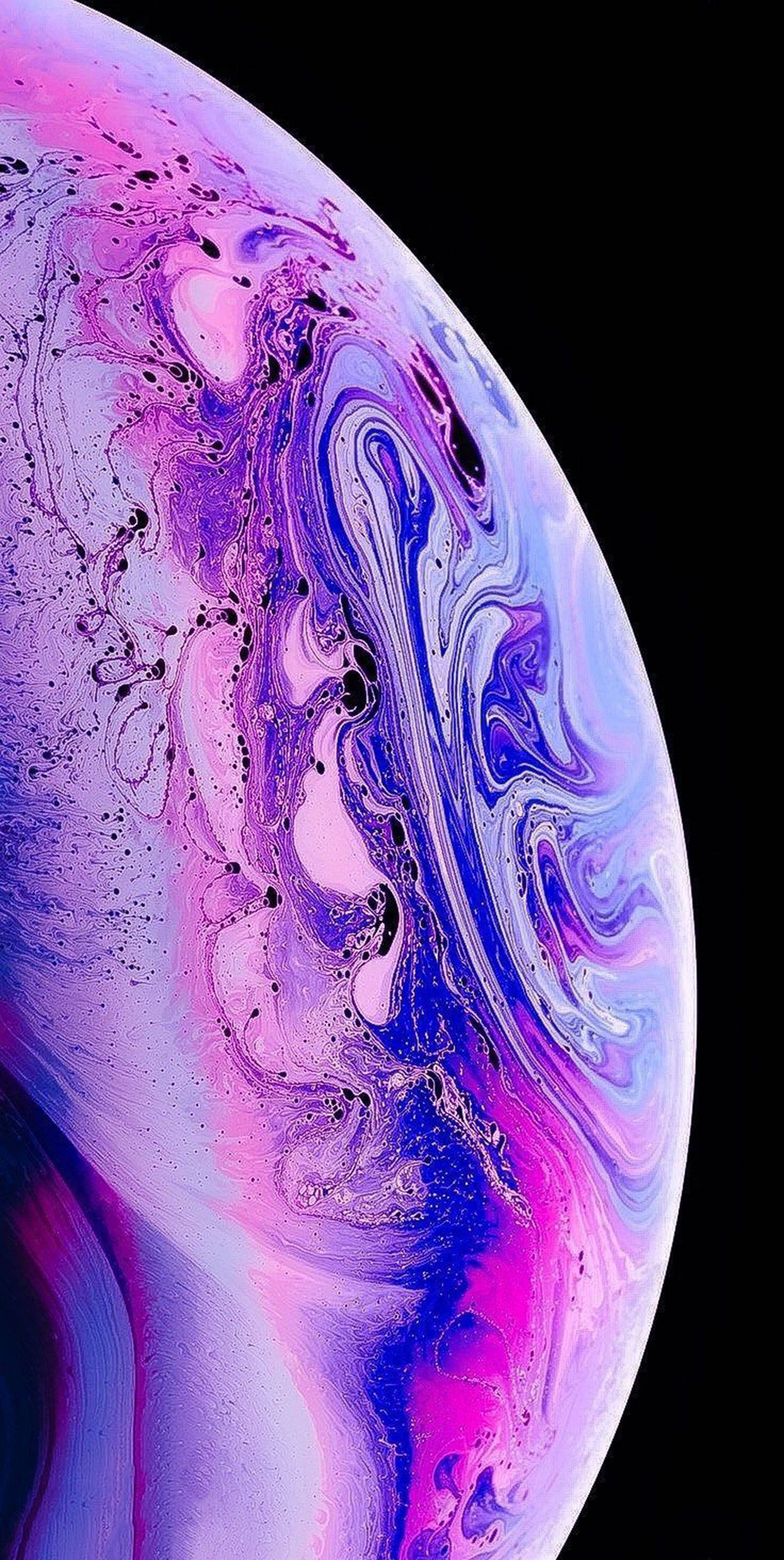 粉紫星球 iOS 16 壁紙 — 一個旋轉的宇宙球體，由鮮豔的紫色、粉紅色和藍色液體顏料構成，背景是漆黑的虛空。