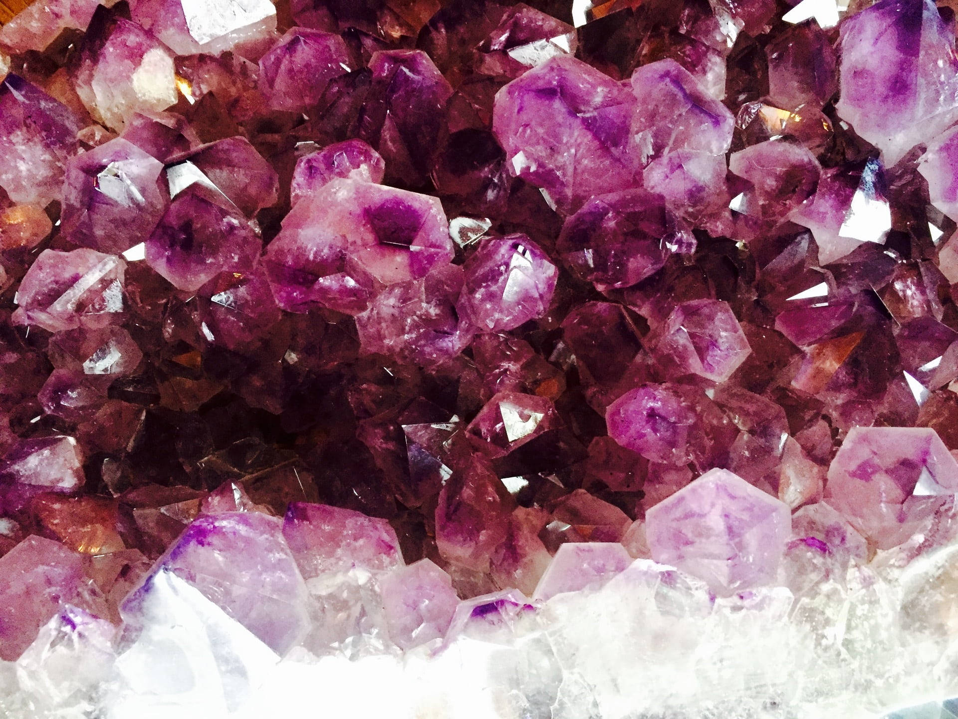 粉紫水晶晶體特寫 壁紙 — 閃爍紫色紫水晶晶體的近距離特寫，具有銳利的刻面和白色底石。